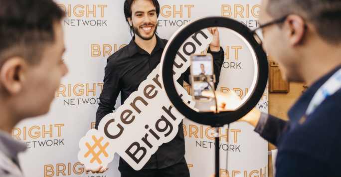 A student posing at the bright futures wall