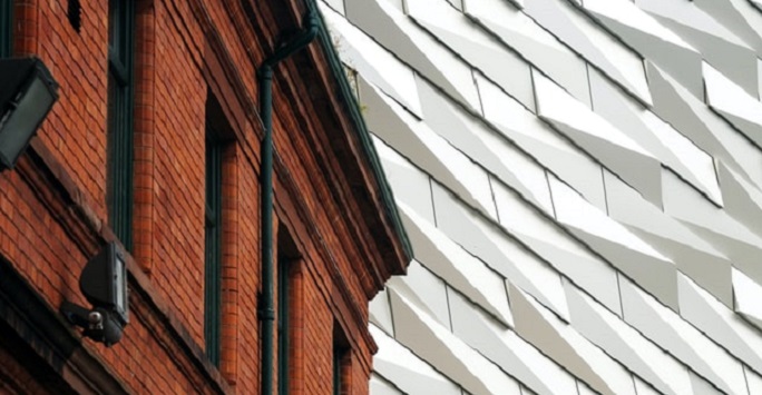 juxtaposed image of traditional brick building against a new modern metal one