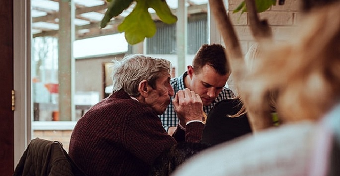 old and young man talking in a coffee shop
