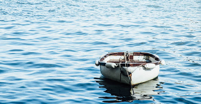 A photo of a run down boat in the sea.