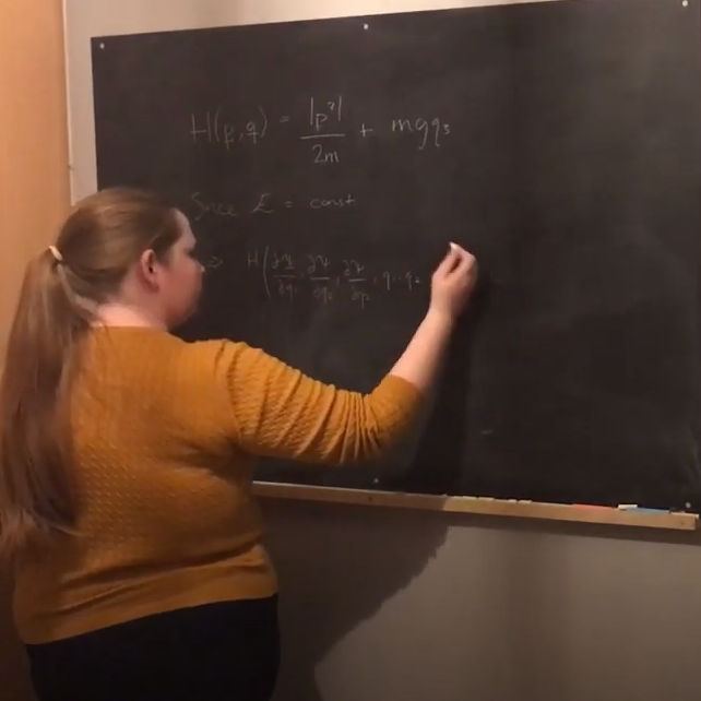 Rebecca writing maths formulas on chalk board