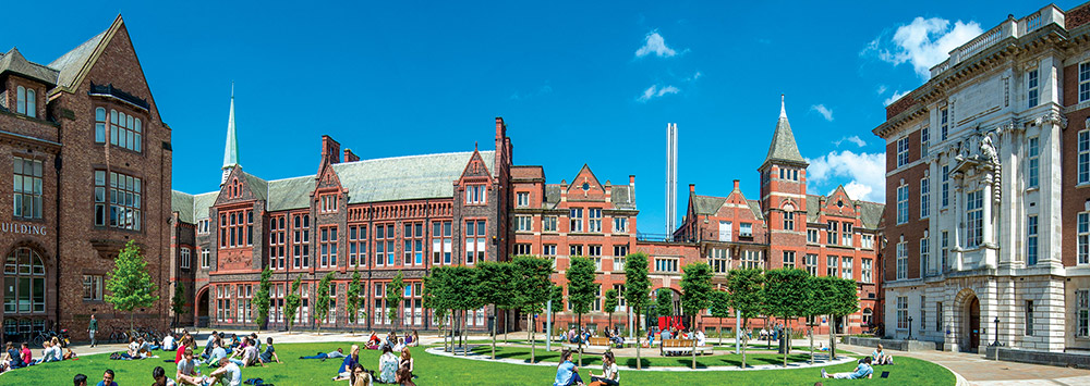 Students relaxing on a grassy area on campus
