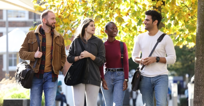 Four students walking through campus.