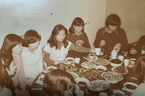 Students from the Liverpool Chinese Society gathered around a table full of food in 1979.