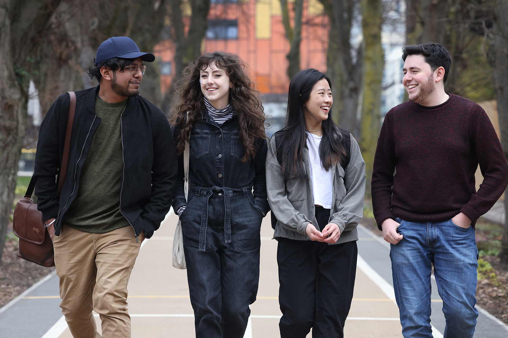 Four students walking through campus together.