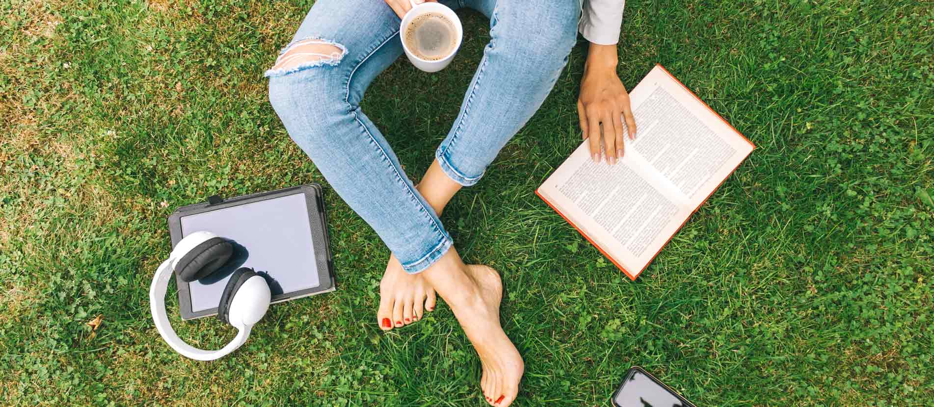 someone reading and drinking coffee at the park