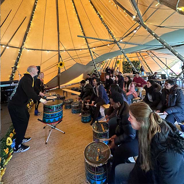 Students taking part in a drumming event during the united by music festival.