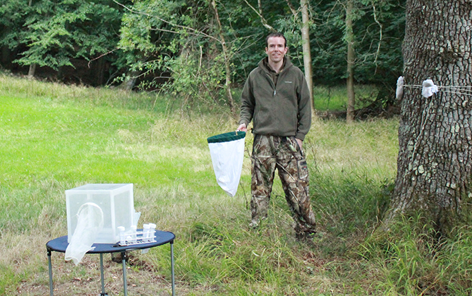 Paul Gilmore conducting fieldwork in a wooded area