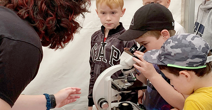 Young people looking at Microscope