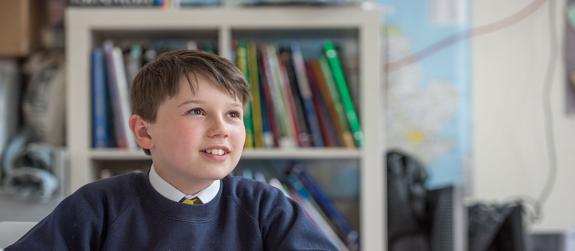 child sitting beside bookcase