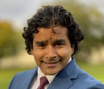 man with curly hair in tie and jacket