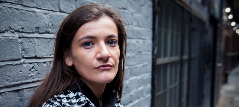 woman standing against wall facing camera