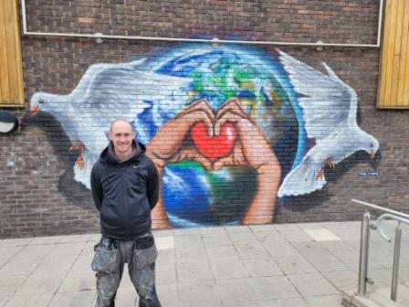 man standing in front of a painting on a wall