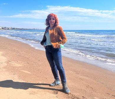 woman standing on a beach with waves in background