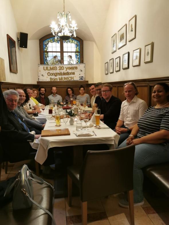 group sitting at a dining table facing camera