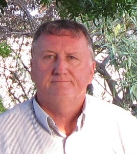 man in shirt standing in front of a tree