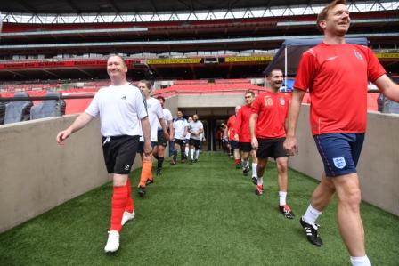 two teams of men entering football pitch from tunnel