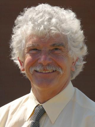 man with moustache and white hair facing camera