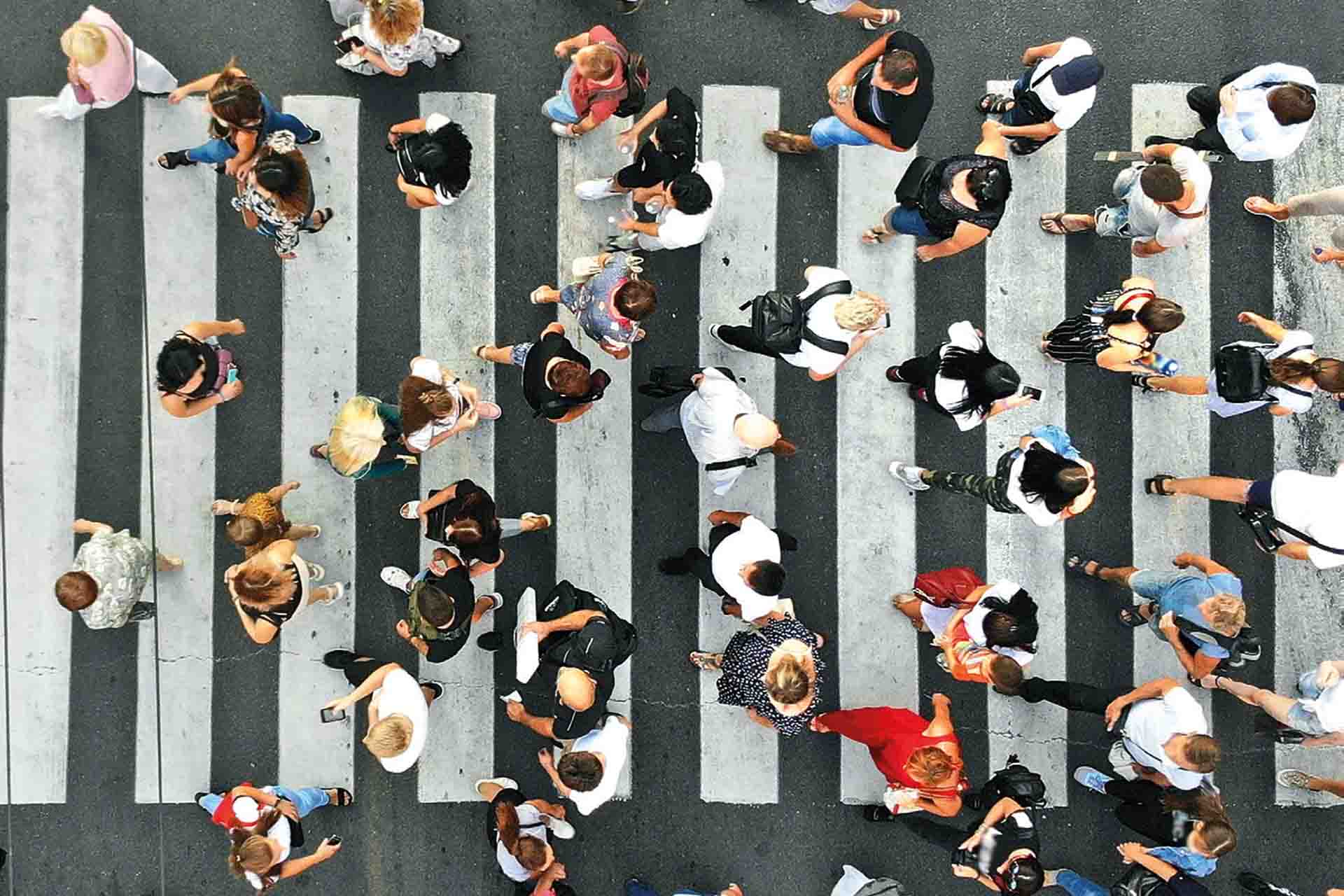 Crowd of people crossing the road in opposite directions