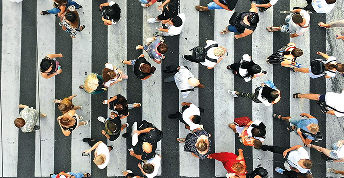 Crowd of people crossing the road in opposite directions