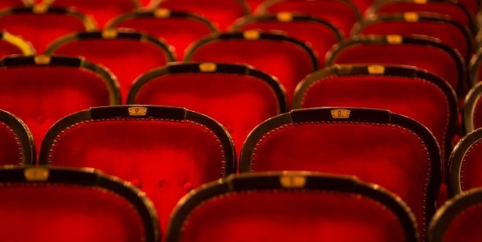 Empty red velvet chairs in theatre