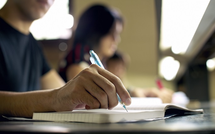 Student works in workbook in library