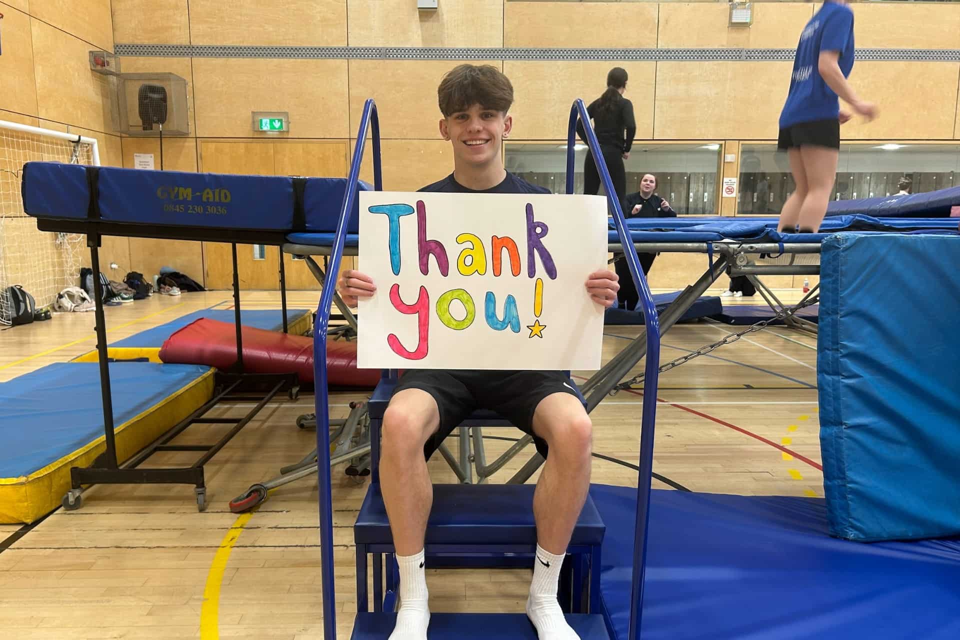 Student holding a thank you sign