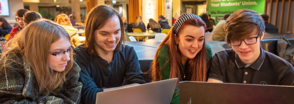 Group of students looking at a laptop