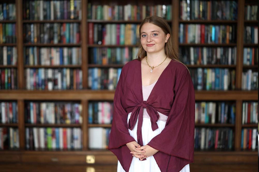 Person standing in front of a bookshelf