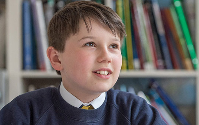 child sitting beside bookcase