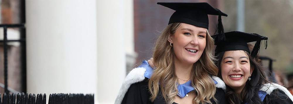 Two graduates in their academic dress on graduation day