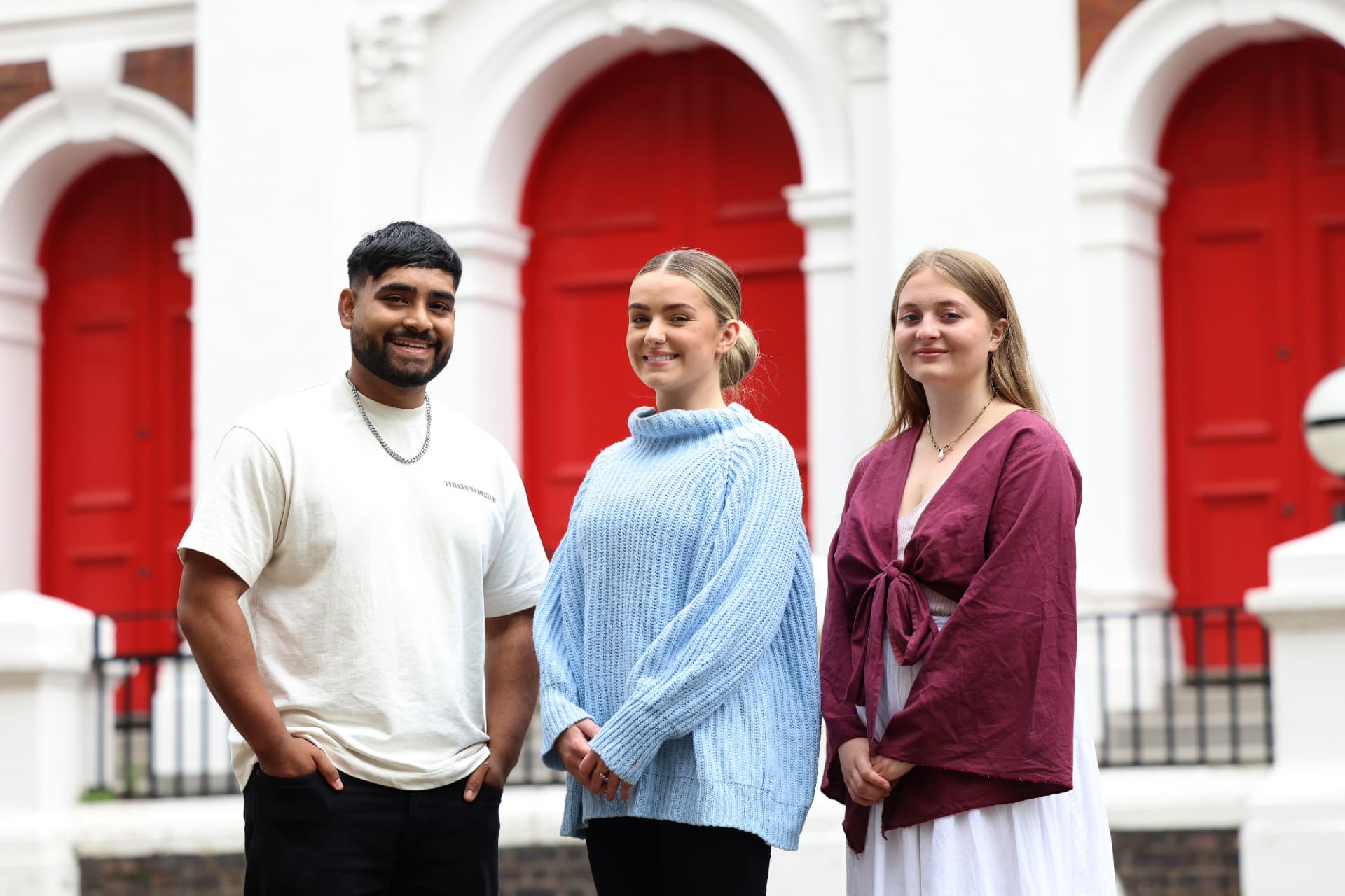Three University of Liverpool students in front of a campus building