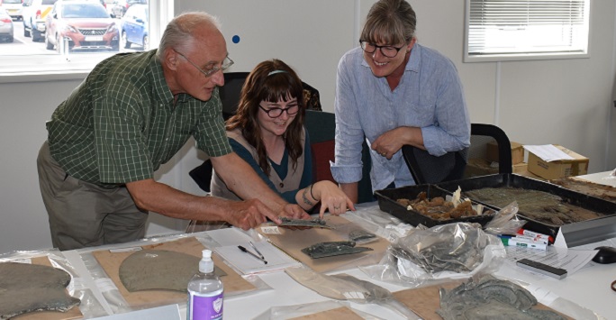 Professor Harold Mytum discusses coffin fittings with Ashleigh Neil and Jane Owen