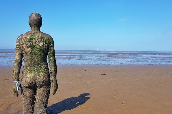 Image of an Iron Man from Crosby beach on a sunny day.