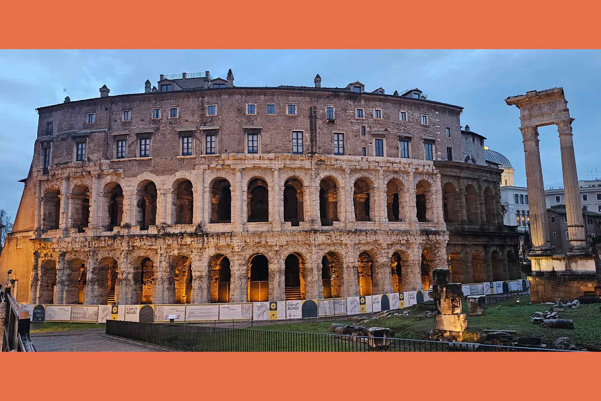 A old Roman amphitheatre in a city at dusk.