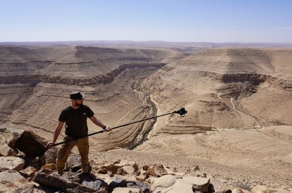 Diederik documenting the massive tower structure with the wadi in the background