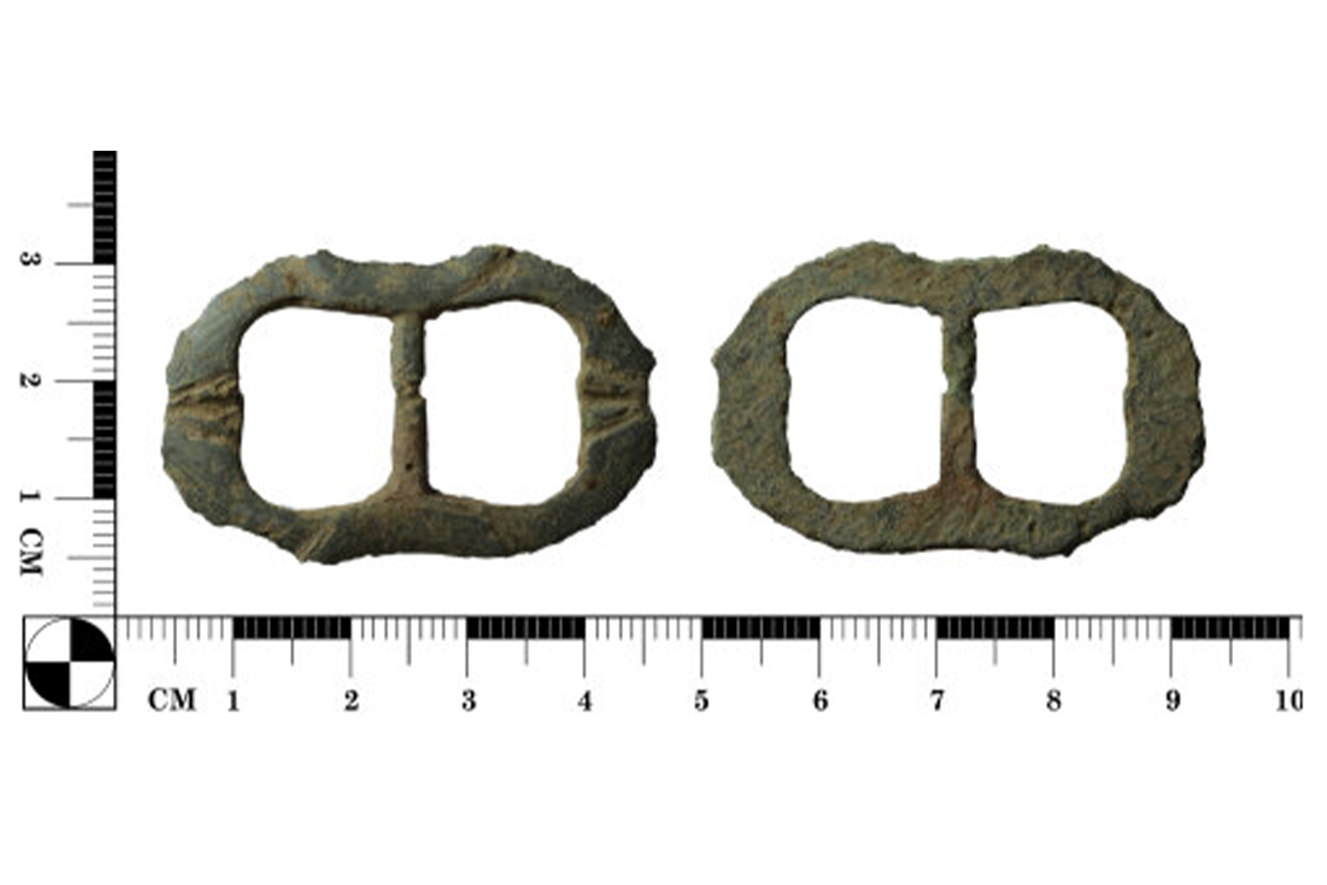 A archaeological find of a copper alloy buckle in front of a ruler showing it to be 4.5cm wide and 3cm tall.