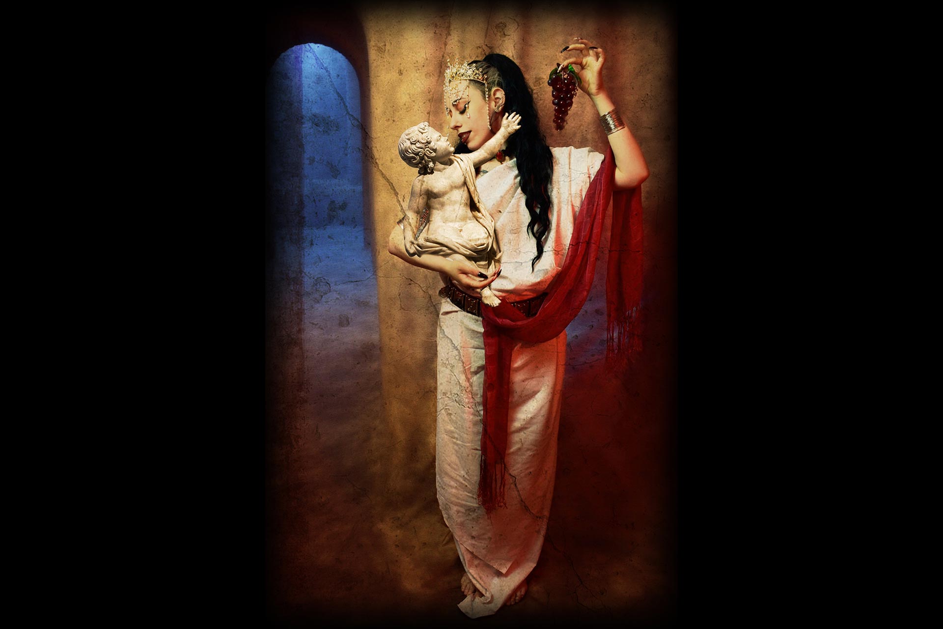 A woman dressed in roman clothes holding a statue of a baby