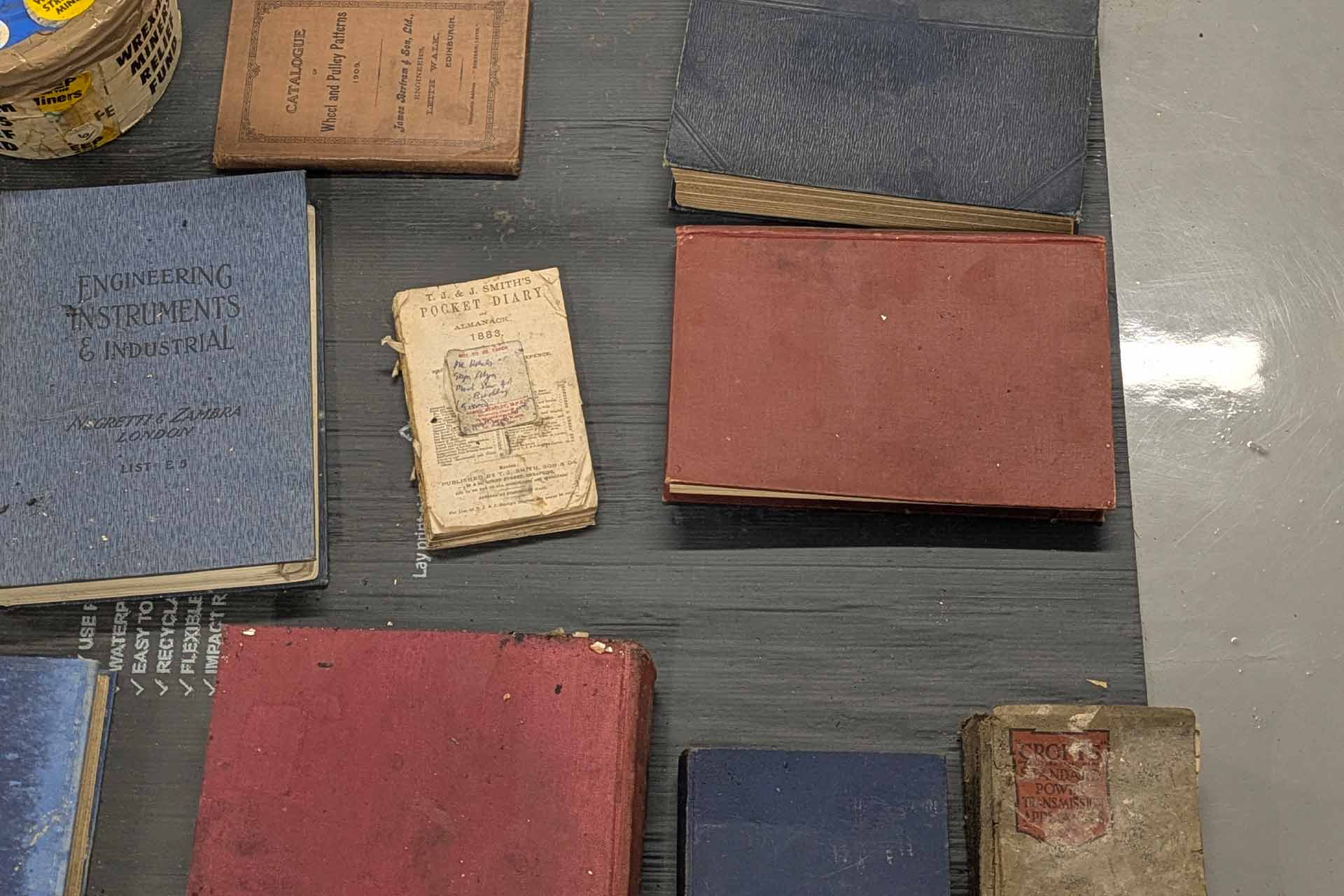 A selection of different colours and sizes of old books laid on a table.