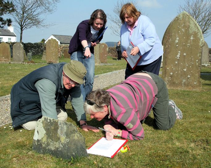Researchers examining a gravestone. 