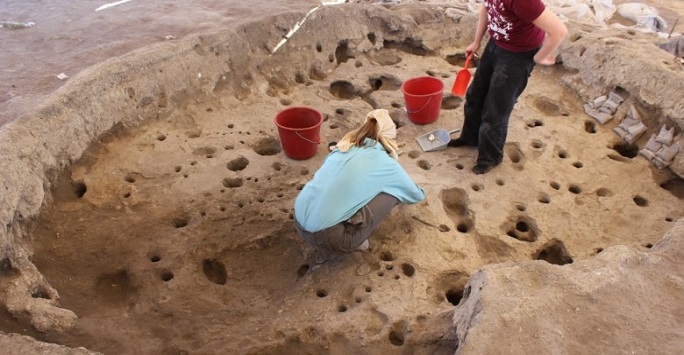 female archaeologist in blue tshirt excavating bonkulu site