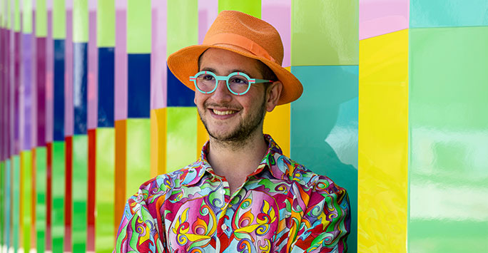 Cheerful man wearing glasses and a wide brimmed hat.