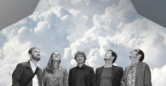 Four men and one woman, all wearing casual clothes superimposed against a cloudy blue sky.