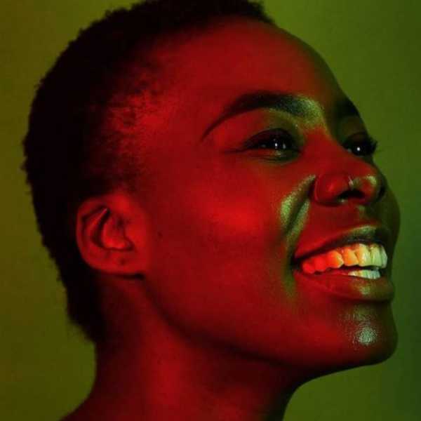 Head shot of a smiling young black woman with short afro hair.