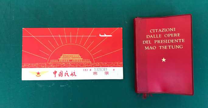 A vintage airline ticker with a chinese temple and stylised jet plane on the cover, next to it is a red book containing the teachings of Chairman Mao.