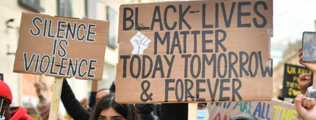 Cardboard placards at a street protest, one reads 