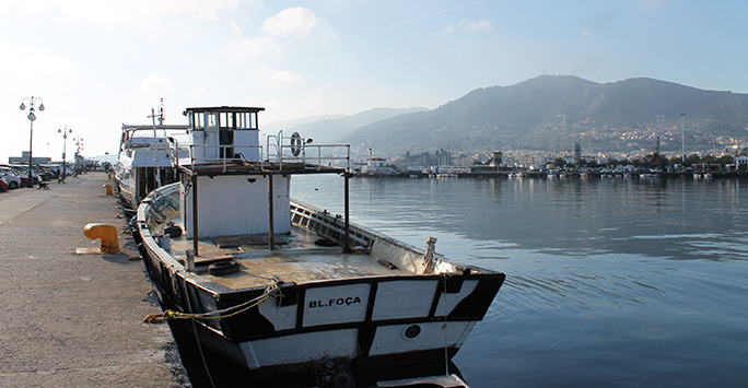 A boat that was used by the refugees to cross from Turkey to the island is left in the main port.