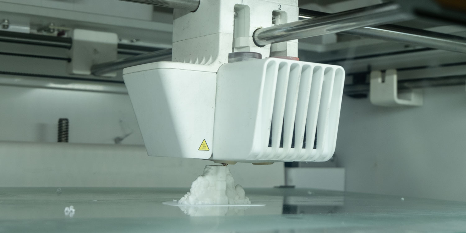 Rectangular head of a 3D printer printing a length of wall.