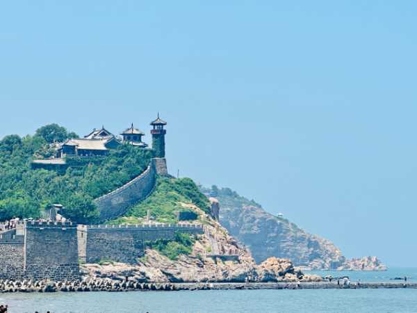 A Chinese castle on a hill overlooking a bay.