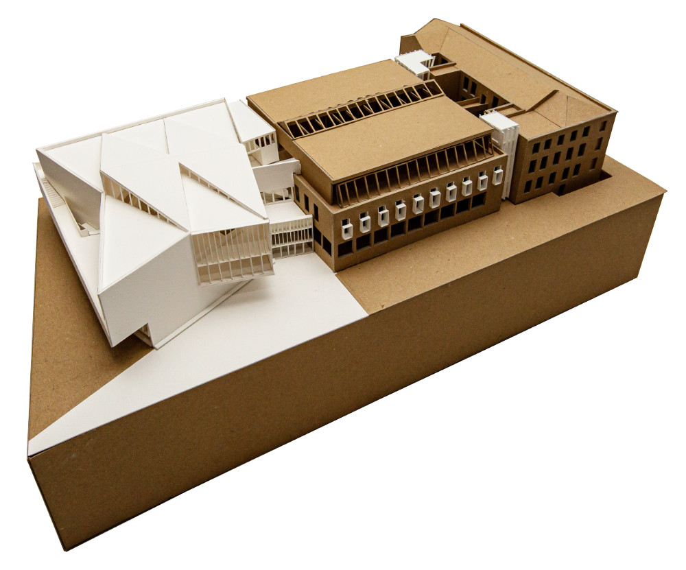 Three quarter view looking down at a model of a proposed building in context with existing buildings